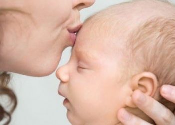 woman kissing babys head (foto: freepik)
